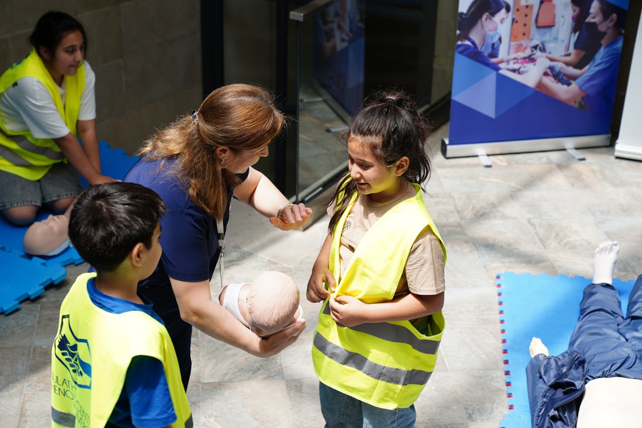 Kids and instructor learning CPR techniques during first aid safety training.